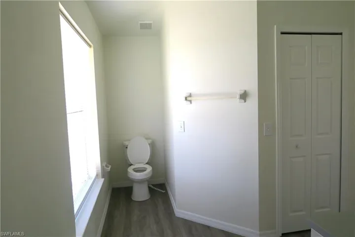 Bathroom with a closet and dark wood-type flooring