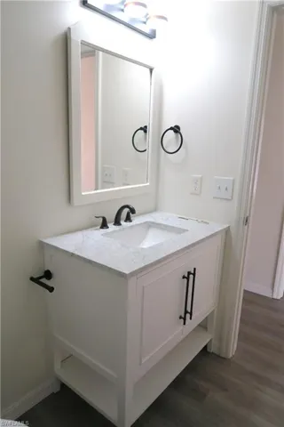 Bathroom featuring vanity and dark wood finished floors
