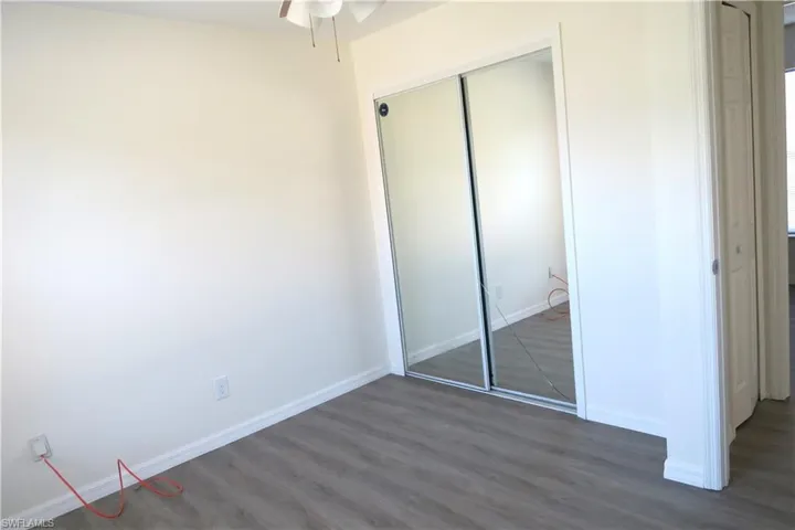 Unfurnished bedroom featuring dark wood finished floors and a closet