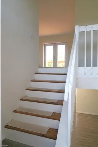 Stairway featuring wood finished floors and baseboards