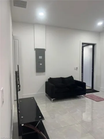 Living room featuring electric panel and recessed lighting