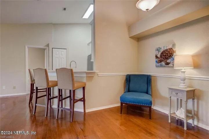 Sitting room featuring hardwood / wood-style flooring and vaulted ceiling