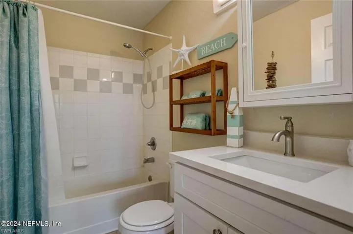 Full bathroom featuring vanity, shower / tub combo, and toilet