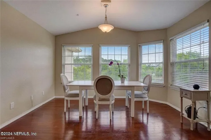 Dining space featuring dark hardwood / wood-style floors and lofted ceiling