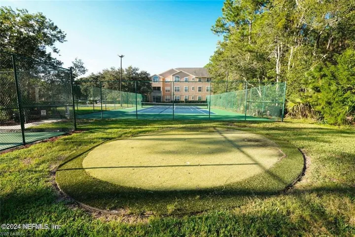 View of home's community featuring a yard and tennis court