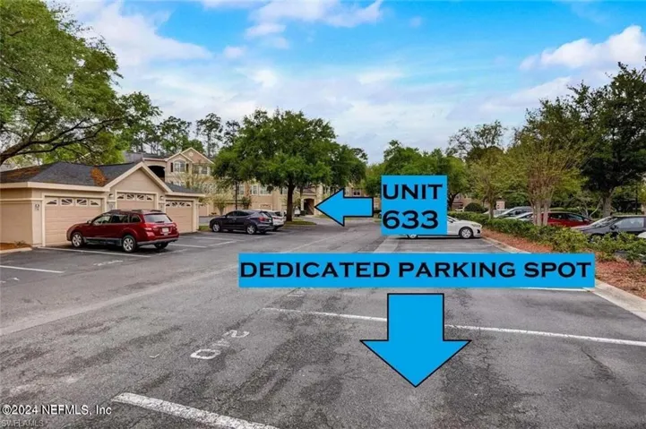View of parking / parking lot featuring a garage