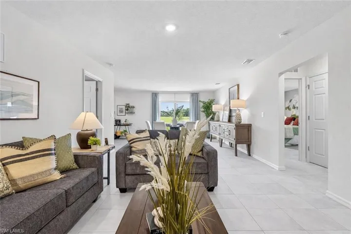 Living area featuring light tile patterned floors and a textured ceiling