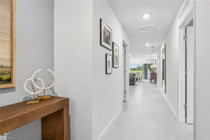 Corridor with recessed lighting and light tile patterned flooring