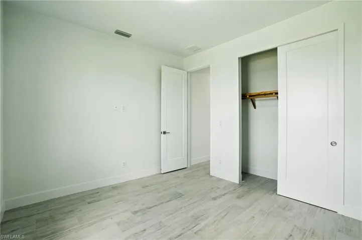 Unfurnished bedroom with light wood-style flooring and a closet
