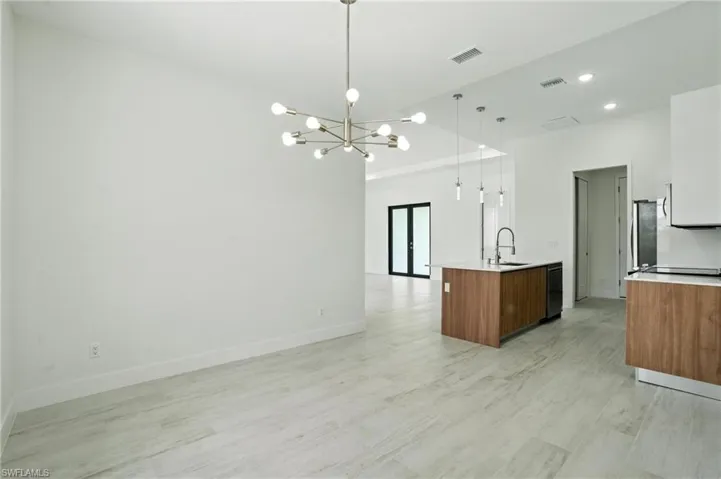 Kitchen with open floor plan, light countertops, brown cabinets, and recessed lighting