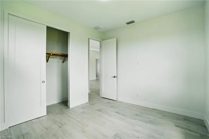 Unfurnished bedroom featuring light wood finished floors and a closet