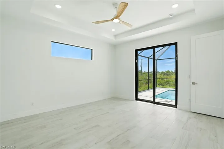 Spare room with a raised ceiling, a sunroom, ceiling fan, light wood-type flooring, and recessed lighting