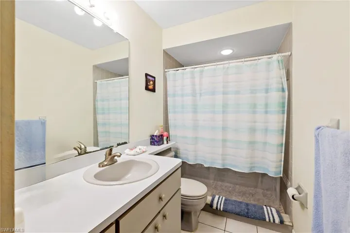 Bathroom featuring tile patterned floors, vanity, toilet, and walk in shower