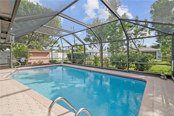 View of pool featuring glass enclosure and a patio