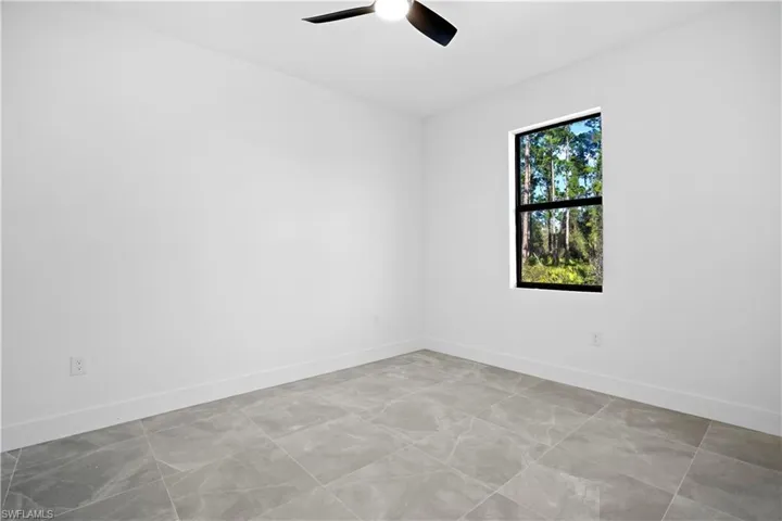 Empty room featuring baseboards and ceiling fan