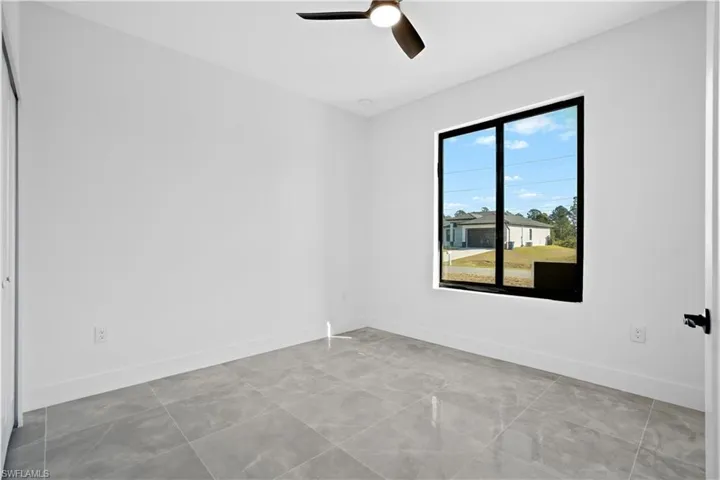 Unfurnished room with baseboards and a ceiling fan