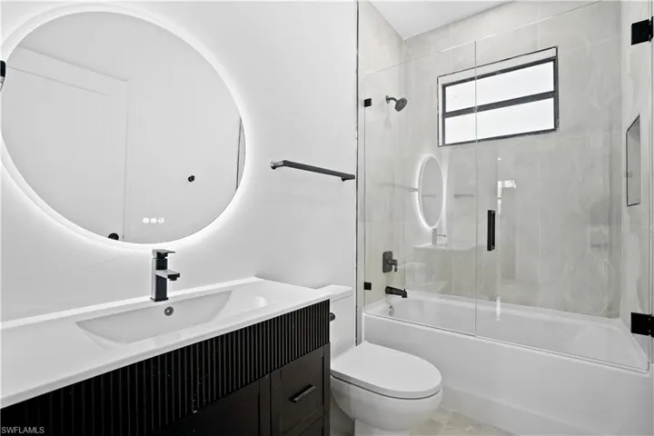 Bathroom featuring vanity and enclosed tub / shower combo