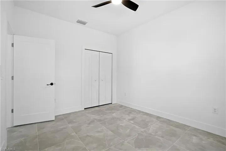 Unfurnished bedroom featuring ceiling fan and a closet