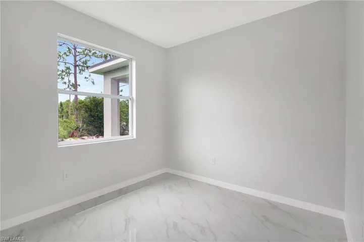 Empty room with marble look tiles and baseboards