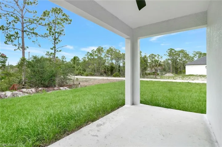 View of grassy yard featuring a patio area