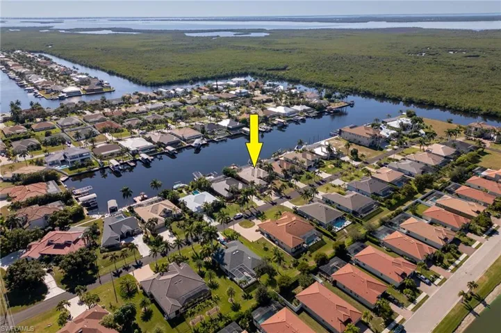 Aerial view of property and surrounding area with nearby suburban area and a large body of water