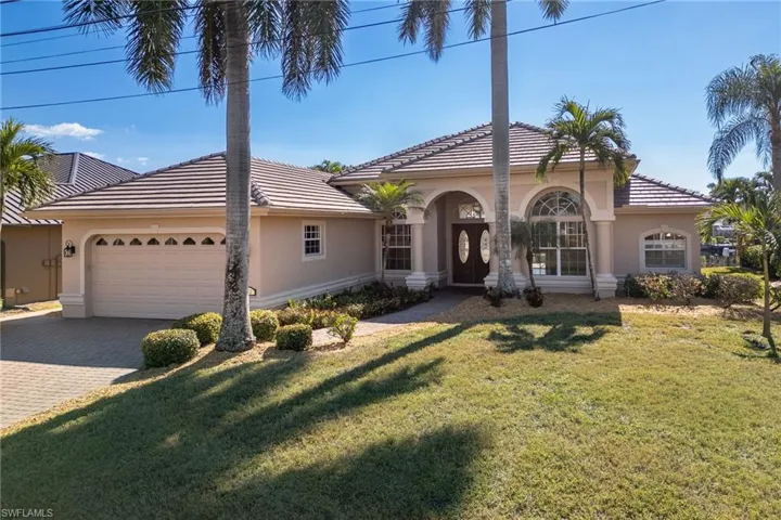 Mediterranean / spanish home with an attached garage, driveway, and stucco siding