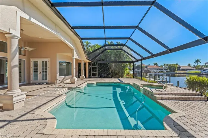 Integrated pool / spa featuring french doors, a patio, a lanai, and a water view