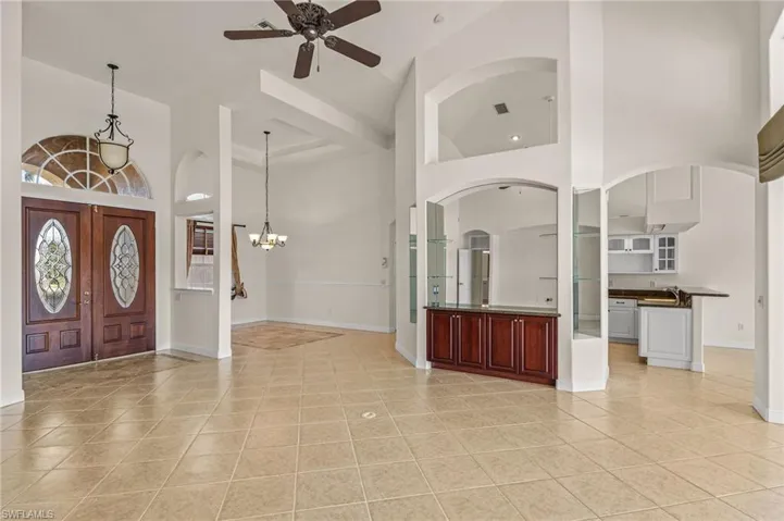 Entrance foyer featuring a high ceiling, ceiling fan, hanging lights, and light tile patterned floors