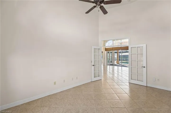 Unfurnished room with french doors, a high ceiling, ceiling fan, and light tile patterned flooring