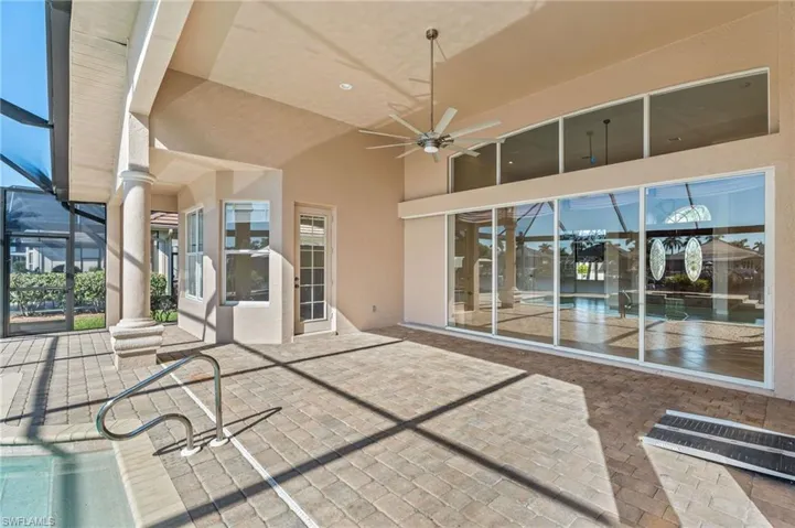 View of patio featuring a ceiling fan and glass enclosure