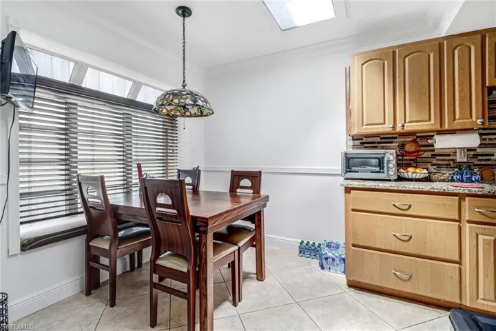 Dining room featuring ornamental molding, a skylight, plenty of natural light, and light tile patterned flooring