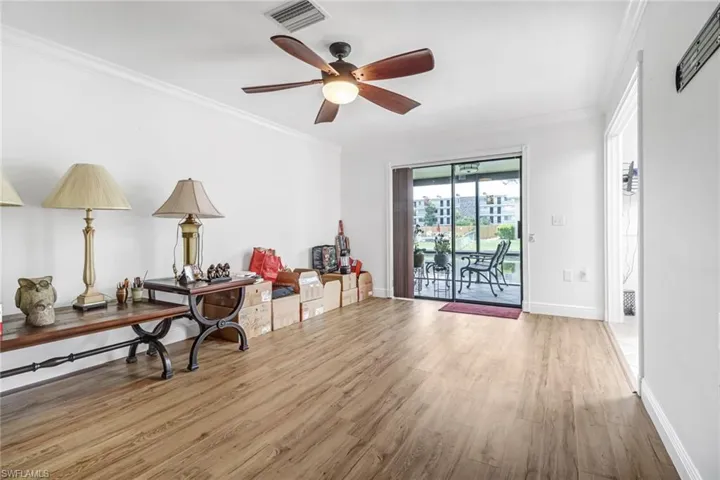 Living area featuring ceiling fan, hardwood / wood-style flooring, and ornamental molding