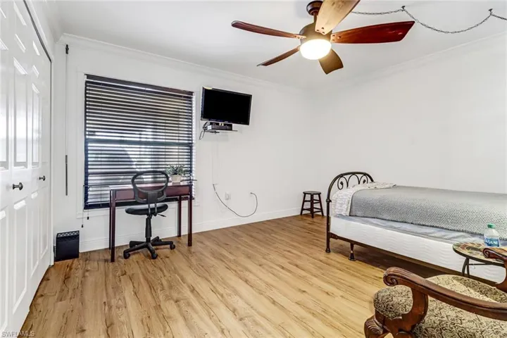 Bedroom featuring ceiling fan, ornamental molding, a closet, and light hardwood / wood-style floors