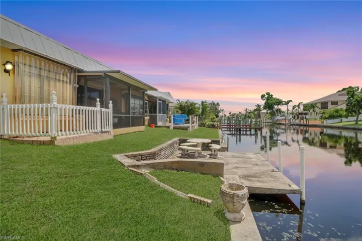 View of dock featuring a yard and a water view
