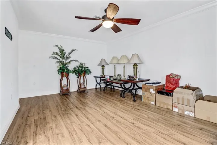 Sitting room featuring light wood-type flooring, ornamental molding, and ceiling fan