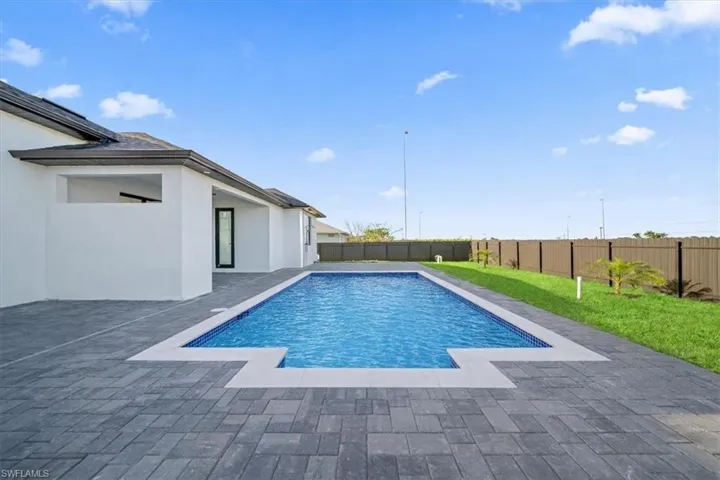View of swimming pool featuring a fenced backyard and patio surround