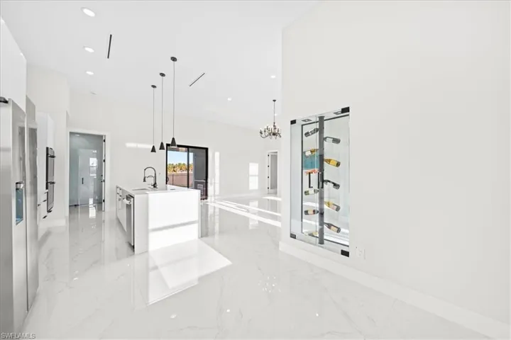 Kitchen featuring an island with sink, modern cabinets, white cabinets, and open floor plan