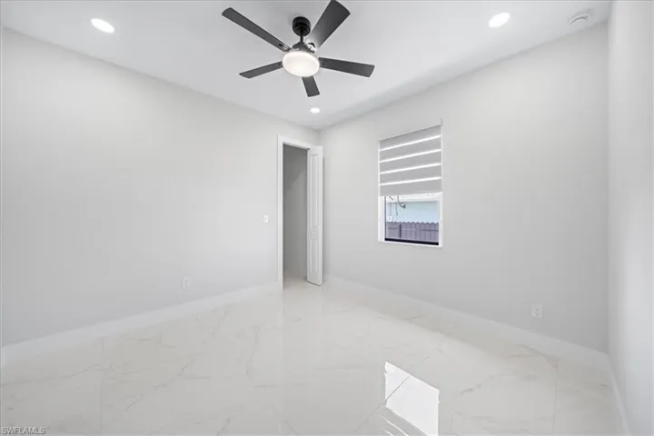 Empty room with recessed lighting, light marble finish floors, and a ceiling fan