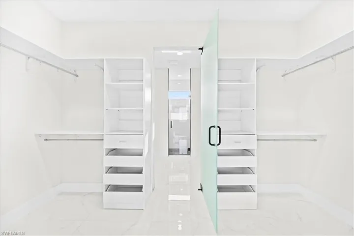 Walk in closet with light marble finish floors