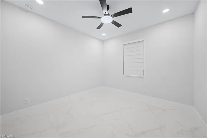 Spare room with recessed lighting, light marble finish floors, and ceiling fan