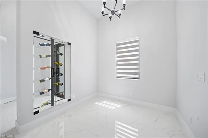 Empty room featuring light marble finish floors and suspended lighting