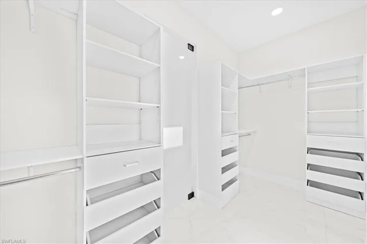 Walk in closet featuring light marble finish floors