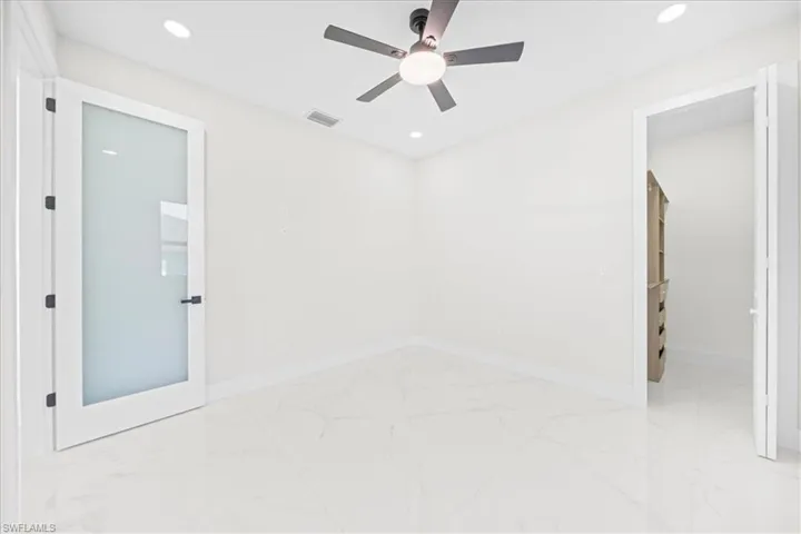 Empty room with recessed lighting, a ceiling fan, and light marble finish flooring