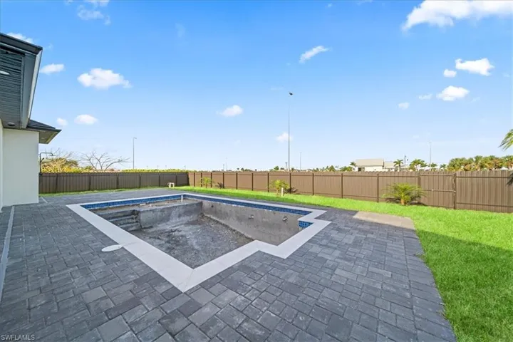 View of swimming pool featuring patio surround and a fenced backyard
