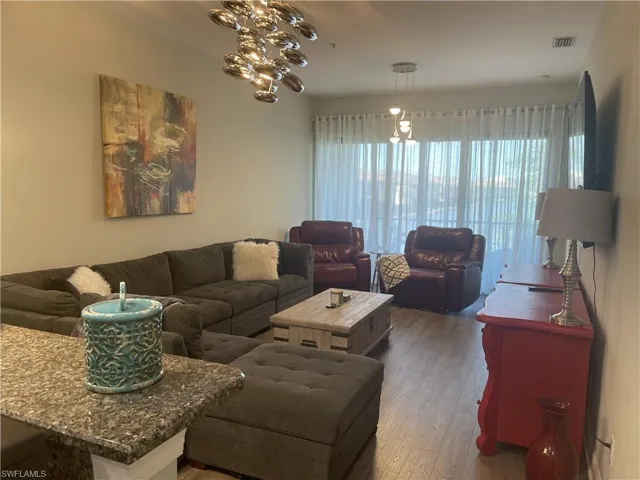 Living area with hardwood / wood-style floors and suspended lighting