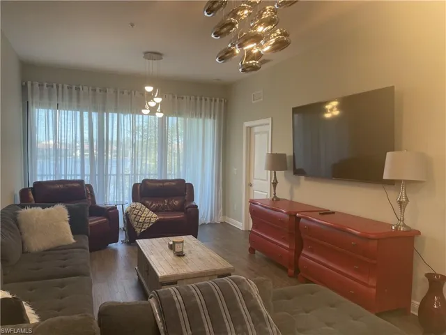 Living room featuring a chandelier and dark wood-style floors