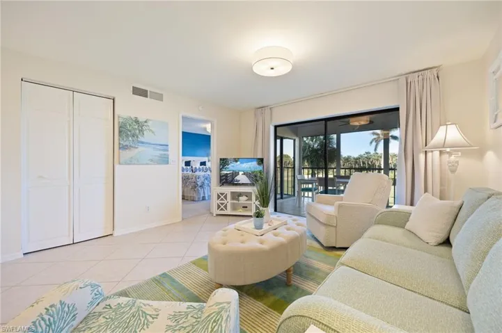 Living area with light tile patterned flooring looking towards owner's suite and lanai.