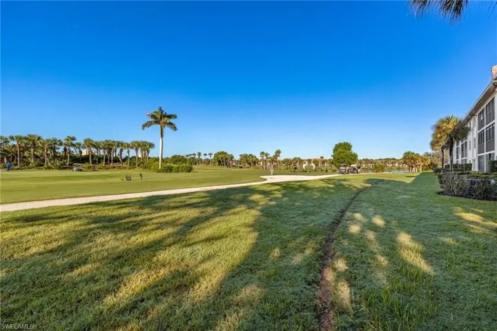 View of green lawn with view of golf course