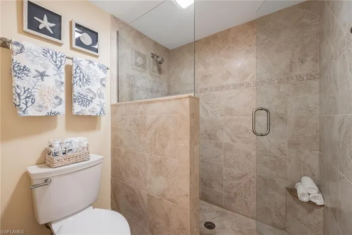 Bathroom with a tile walk in shower and new toilet