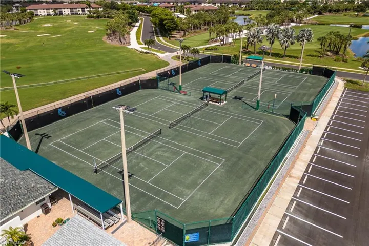 View of tennis court with a water view and golf course view
